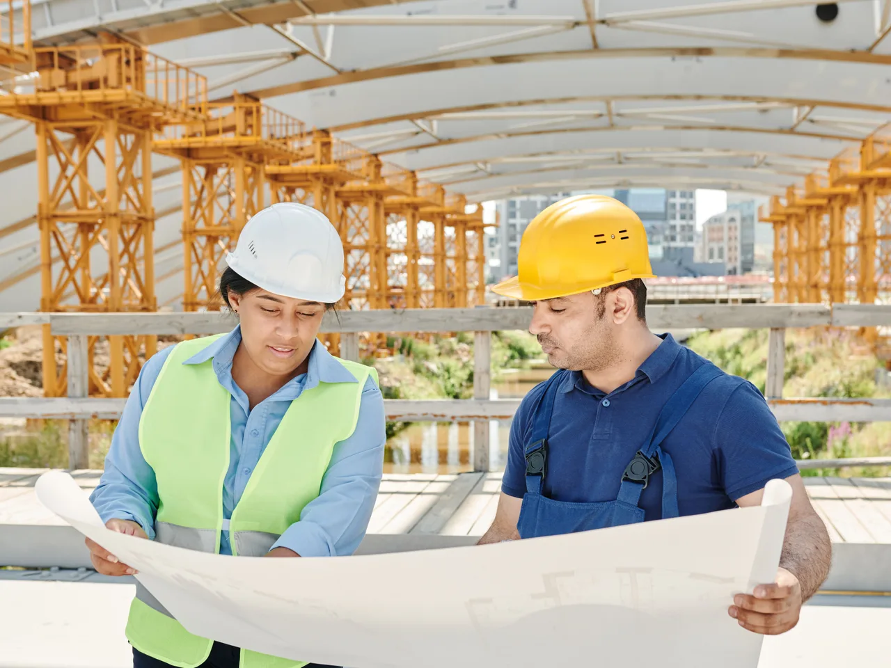 Engineers reviewing project drawings at an industrial construction site